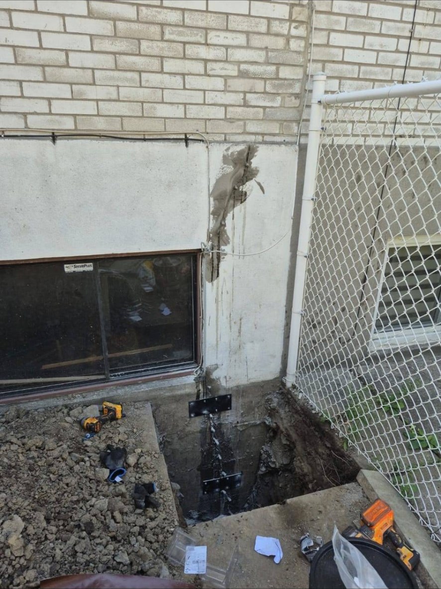 Fosse creusée devant une fenêtre de sous-sol